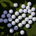 Multiple golf balls arranged on a green surface with a blurred background